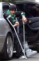 Manchester United's midfielder and England captain David Beckham aided by crutches arrives at his home