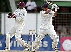 Rahul Dravid of India bats as West Indies wicketkeeper Junior Murray waits for the throw