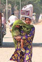 A young woman provides succour to her child from the scorching sun 