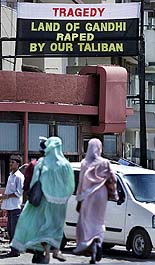 Women walk past a billboard