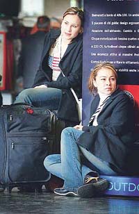 US students Perla Aguirre (L) and her sister Brenda from Park City, Utah sit on their luggage
