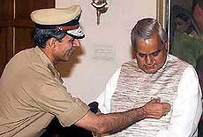 Chief Fire Officer R. C. Sharma pins up a flag on Prime Minister Atal Behari Vajpayee