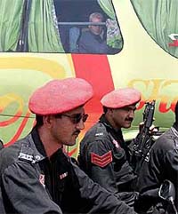 A member of the New Zealand cricket team watches Pakistani security guards