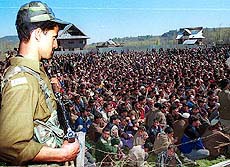A policeman stands guard during a political rally of the ruling National Conference 