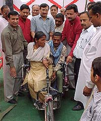 Mr Sewakram Bhola, MC and senior congress leader giving away tricycles to the 