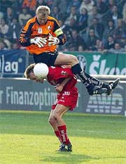 Goalkeeper Franz Almer from Grazer AK (top) lands on the back of his team-mate