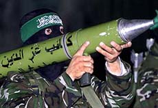 A masked Hamas fighter carries an anti-tank weapon 