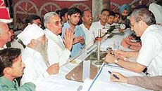 Bidders argue with the Assistant Estate Officer, Mr Ashwani Kumar (extreme right), at the auction of bulk-market sites in Chandigarh on Tuesday.