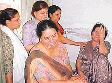 The mother of Rohit being consoled by her neighbours and relatives