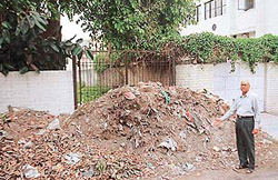 A resident of Sector 21-A points towards the garbage heap in a lane behind a row of houses in Chandigarh on Sunday. 