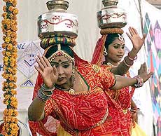 Traditional dancers carrying steel pots on their heads dance at the Red Fort