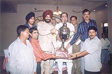 M S Bitta giving away the Jawaharlal Nehru Cricket Tournament trophy to Trans-Yamuna Cricket Association captain Ashish Sharma.