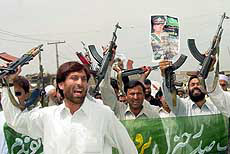 Supporters of Pakistan's President General Pervez Musharraf wave weapons