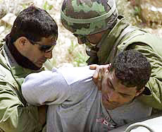 Israeli soldiers scuffle with a Palestinian man