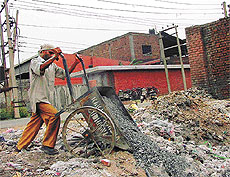 A worker throws industrial waste in a neighbouring empty plot in the Industrial Area