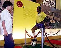 A youngster stands next to a life-size statue of Brazilian soccer legend Edson arantes do Nascimento