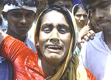 A survivor of a ferry disaster, Julekha, wails for her dead child