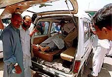 Dead body of one of three shooting victims is brought in an ambulance, on Monday in Karachi, Pakistan.