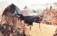 Smouldering jhuggis after a demolition drive