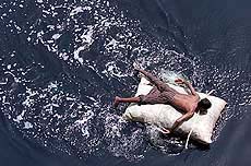 A man floats on a makeshift raft