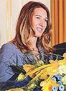 Former German tennis champion Steffi Graf smiles as she holds a bunch of flowers