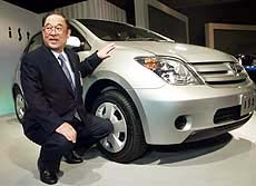 Toyota Motor president Fujio Cho poses beside the new compact car