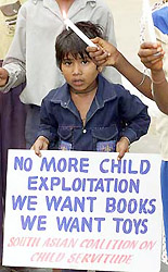 A young boy holds a placard during a candle light vigil