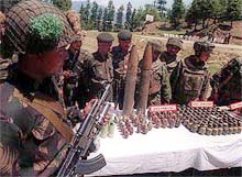 Army Jawans displaying arms and ammunition recovered during search operation