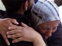 A mother cries on her son's shoulder after he returned from the Church of the Nativity