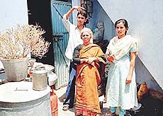 Three members of the Dubey family who were �attacked� by their landlords. Their belongings, that were thrown out of the house, lie scattered near the only room that they presently occupy.