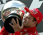 Rubens Barrichello of Brazil holds up the winner's trophy 