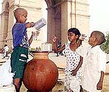 A little water  vendor   serving water to his friends 