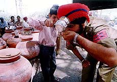 A police man drinking water to quench his thirst as mercury touched 47 degree celsius in Bathinda on Friday.