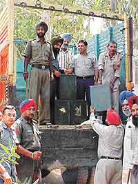 Election officials and security personnel load ballot boxes