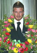 England soccer team captain David Beckham is greeted with a garland of flowers