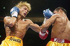 Japanese challenger Osamu Sato launches a left upper hook