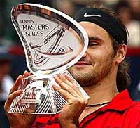Swiss player Roger Federer holds up the trophy 