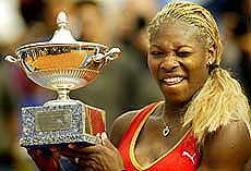 Serena Williams of the USA winks as she shows off her trophy 