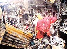 Residents sift through the debris of their makeshift structures