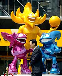 A pedestrian passes the World Cup mascots 