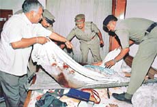 Police personnel remove the body of 78-year-old Prakash Kaur from her Sector 15 residence