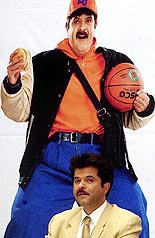 Film star Anil Kapoor sits beside a hoarding