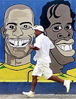 A resident runs next a painting of Brazilian and Italian team Internazionale soccer star Ronaldo