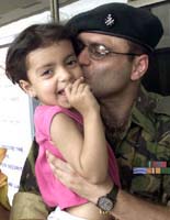 An Indian soldier kisses his daughter