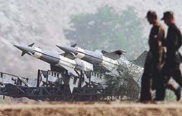 Soldiers walk past Indian missiles