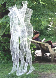 A woman reads next to a sculpture