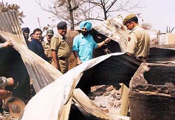 Chairman of All-India Anti-terrorist Front M. S. Biitta surveys the remainings of houses