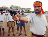 A Bajrang Dal activist holds a pistol during a week-long training camp