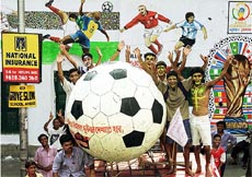 Soccer fans stand in front of a wall painting