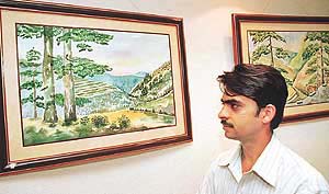 Sudershan Kumar Sharma, an artist from Shimla, with his water-colour paintings at Induslnd Art Gallery, Sector-8, Chandigarh, on Saturday.